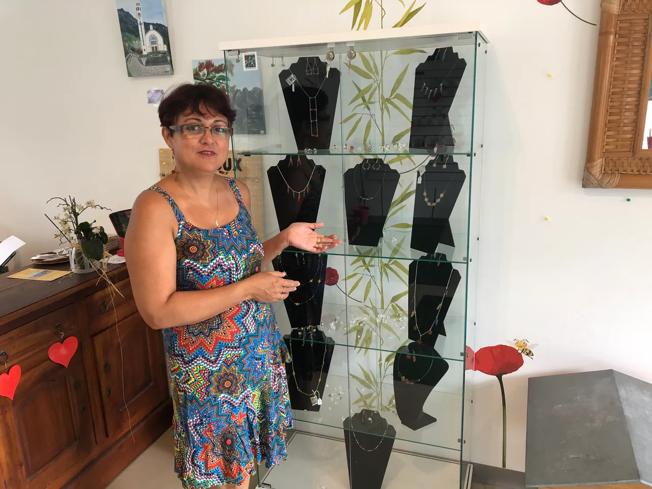 Guylaine Hoarau devant son présentoir de bijoux BEEJOUX